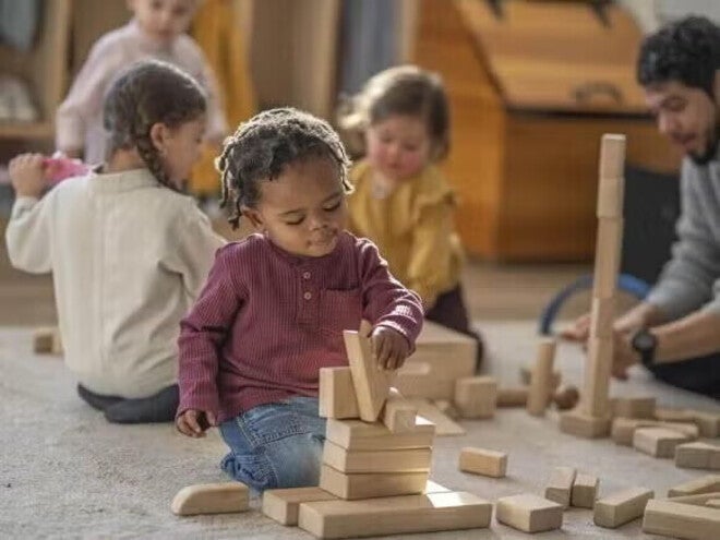 Παιδιά παίζουν με ξύλινα τουβλάκια σε αίθουσα τάξης.