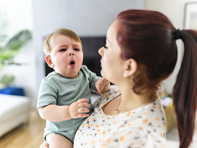 Μαμά κρατά μωρό που βήχει και δείχνει δυσφορία στο σπίτι.